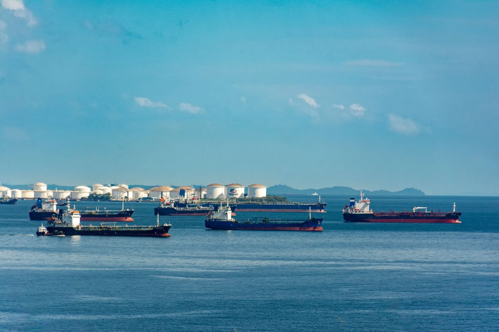 Cargo ships waiting at anchor off a congested coastal port