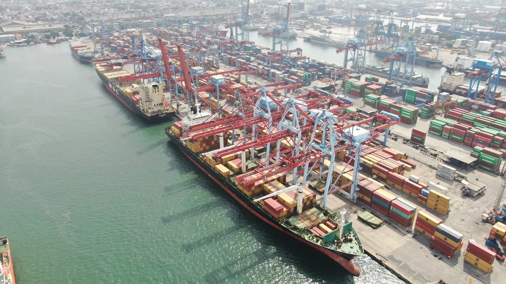 Cargo ships being loaded at a busy container port